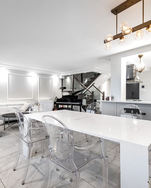 Dining area with a white table and a grand piano